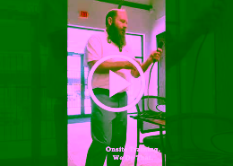 Bearded man leading an onsite training indoors, handling a cable and explaining to an unseen group.